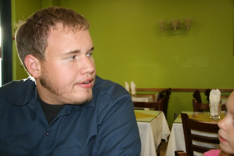 a man looking at a small girl in a restaurant