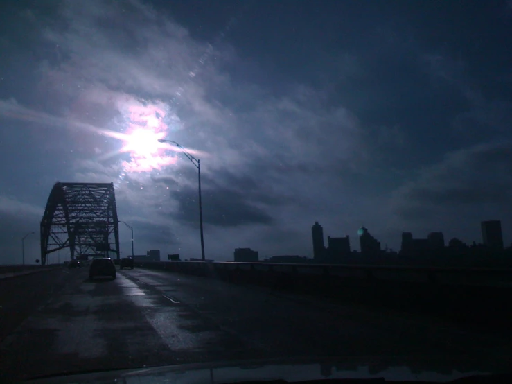 the view of a bridge in the distance from a wet street