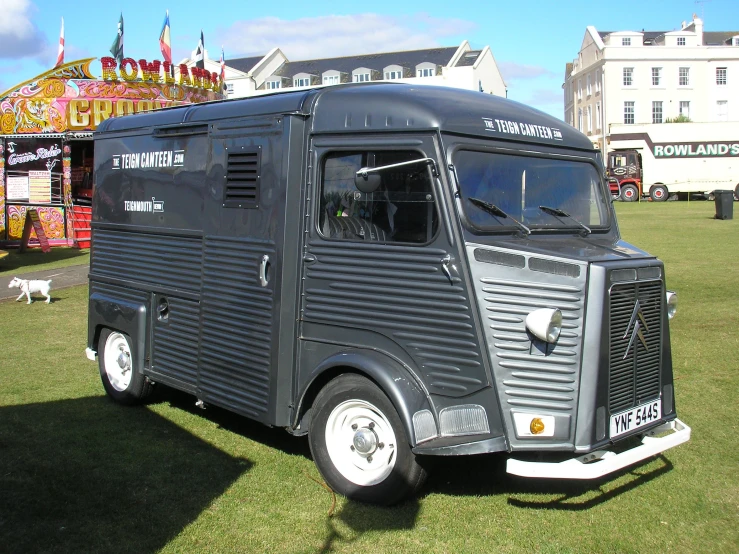 an old fashioned truck on display with many rides in the background