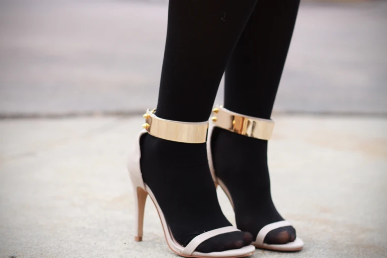 a pair of black and gold high heels and stockings
