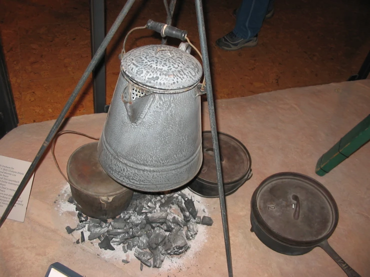 an antique jug is on a table near a pair of gloves