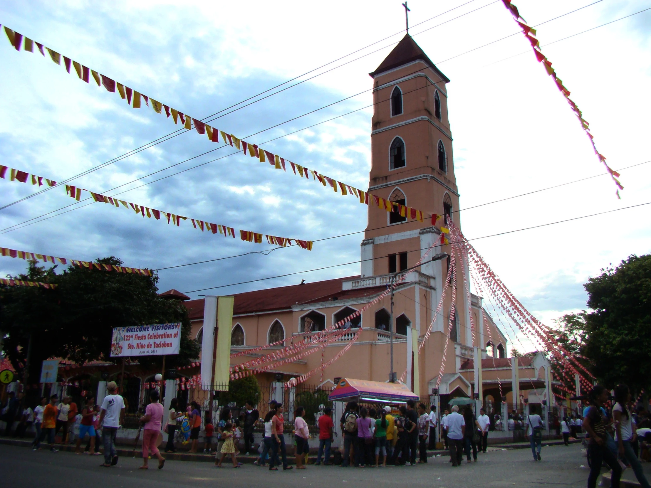 an ornate building with a tall tower and many flags flying in front