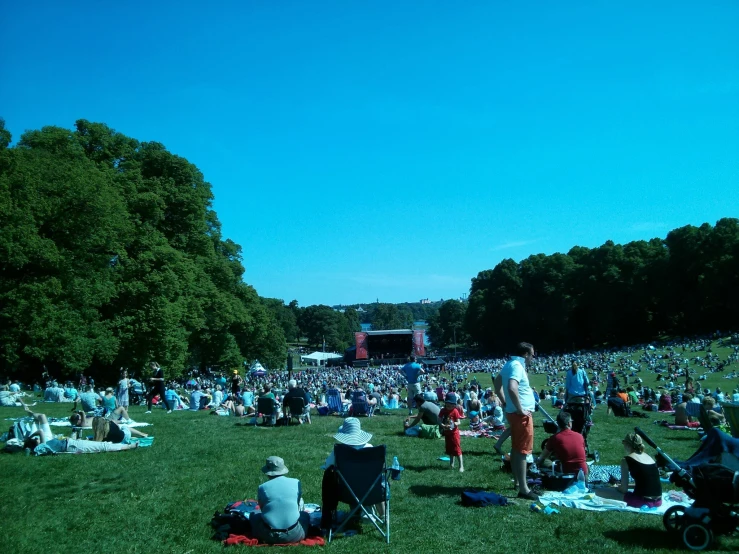 there are a lot of people sitting on the grass