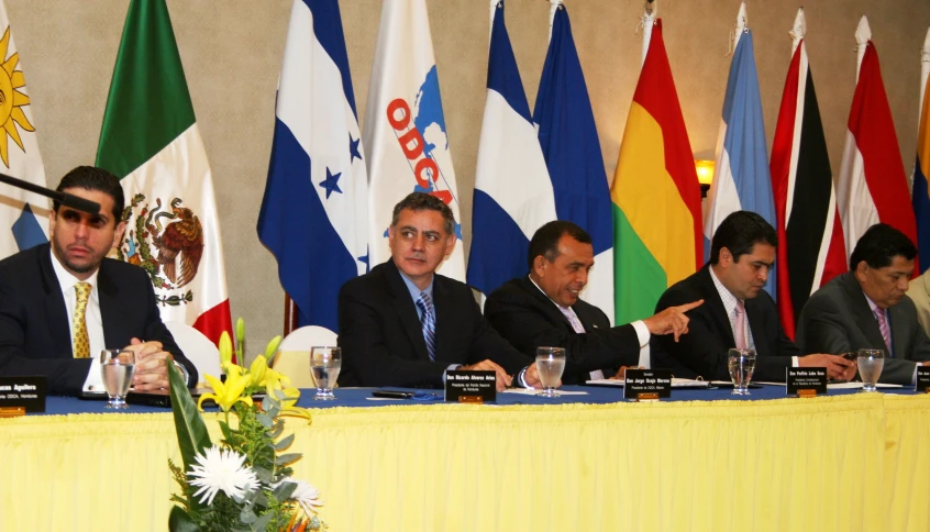 several people sit in front of five flags