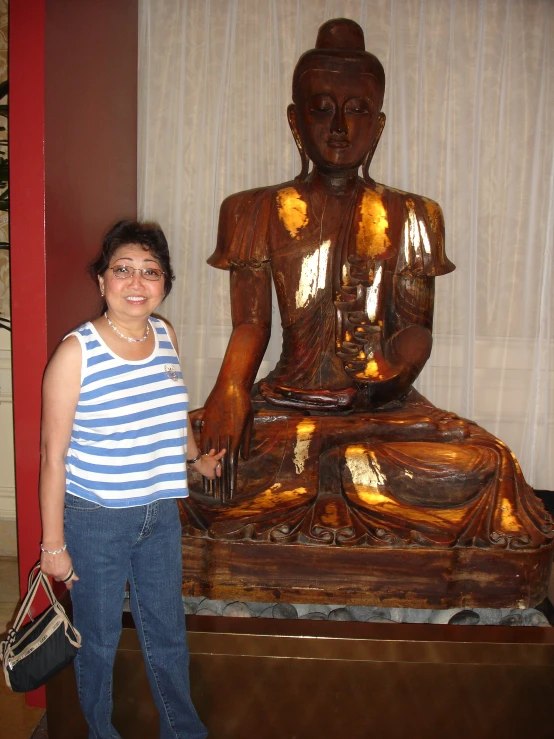 a woman posing next to a gold statue