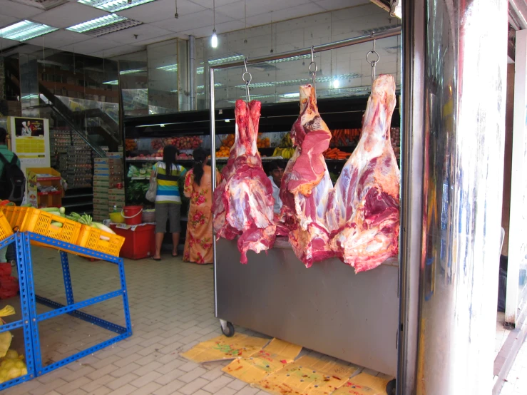 the people are shopping at the store for the meat