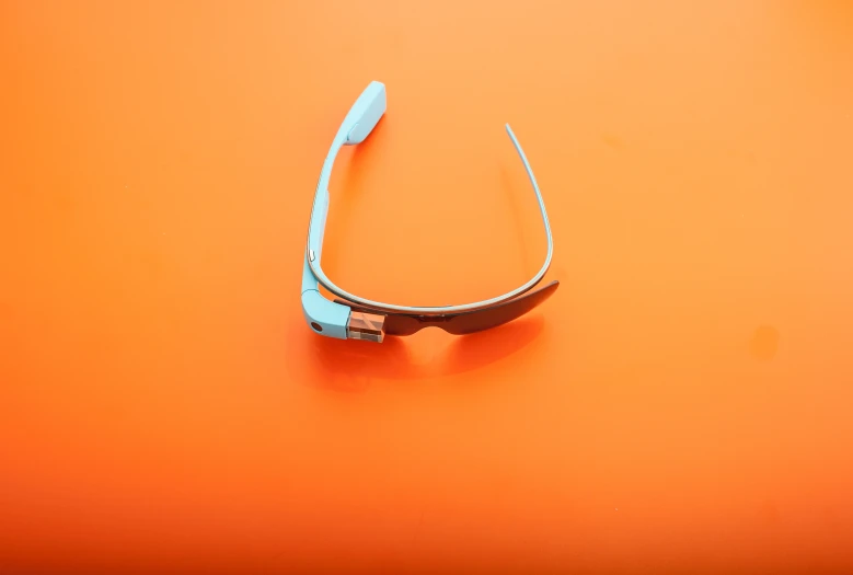 a pair of glasses sitting on top of an orange surface