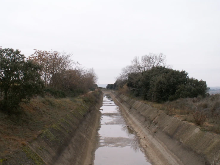 a waterway leading into a hilly area with trees on either side