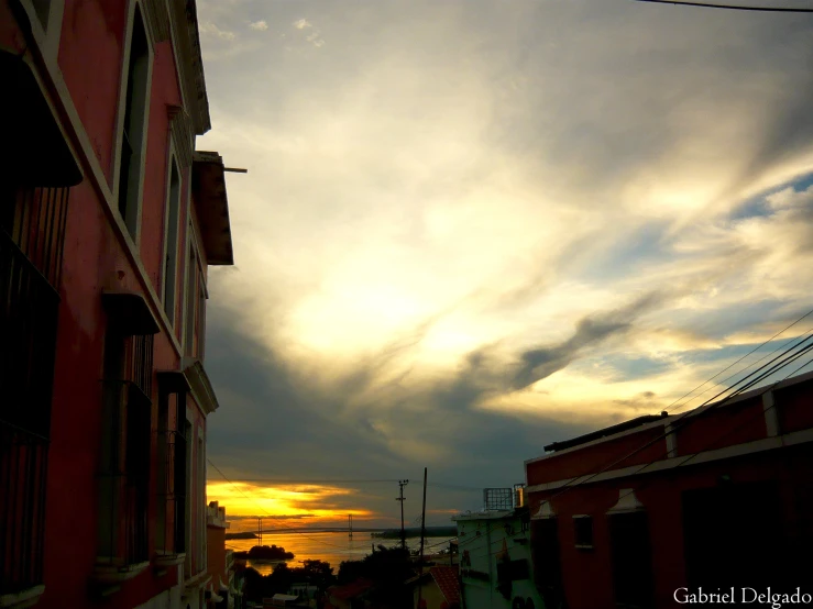 sun setting and clouds in the sky over some buildings