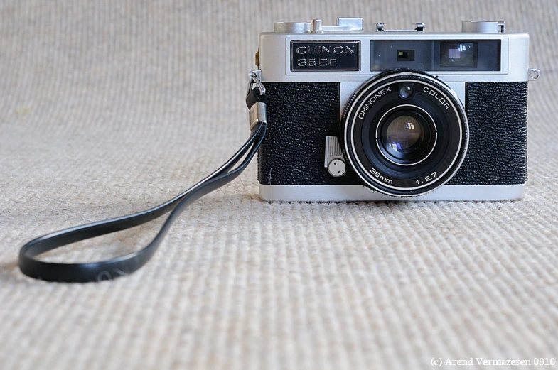 an old fashioned camera with a black strap