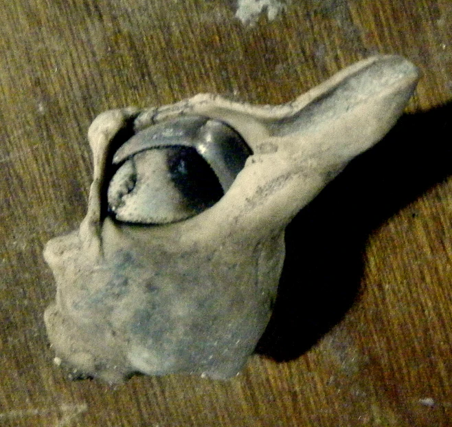 a small ceramic figurine with it's head held up