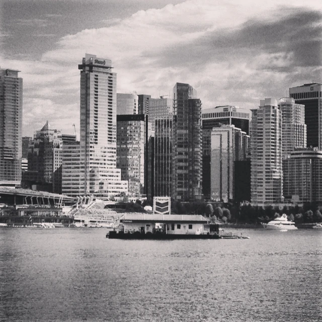 a boat in a body of water in front of some big city buildings