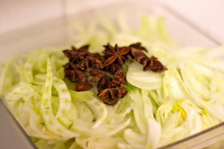 chopped cabbage, with seeds and spices in a glass container