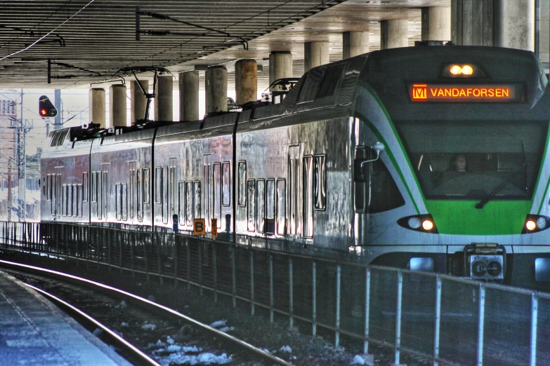 a subway train at a city station with the lights on