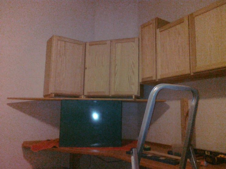 the television is on a stand in the kitchen