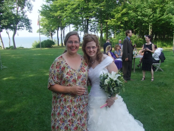 two woman pose for the camera before they are getting married