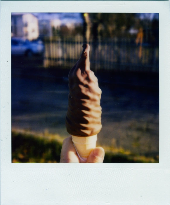 an individual is holding a large ice cream cone