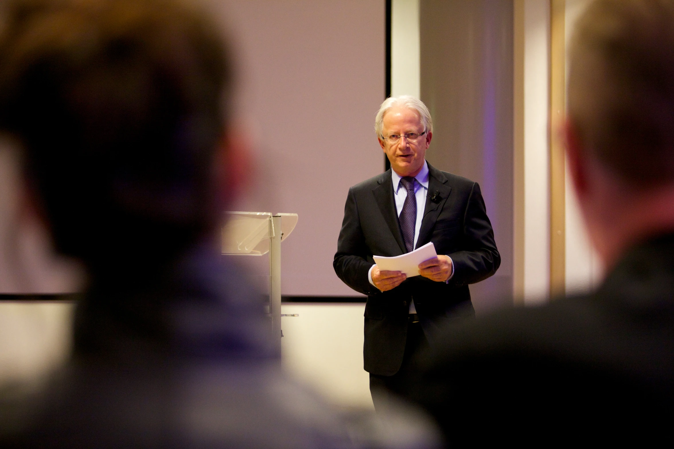 a man standing at a podium giving a lecture