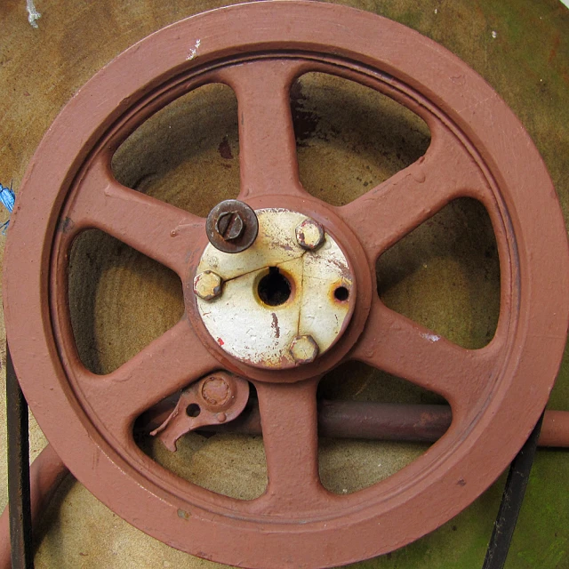 an old red wagon wheels is on the ground