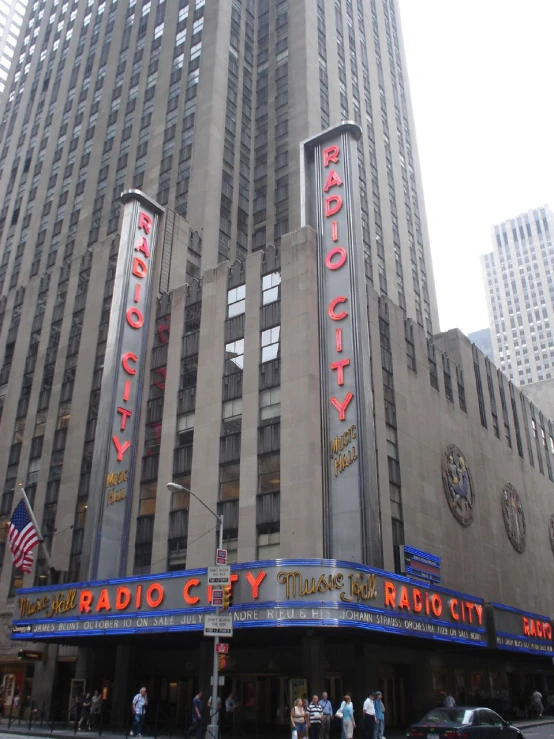 a large building with some lights and many people walking outside