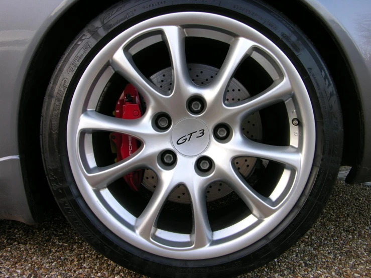 a silver car wheel with red ke pads