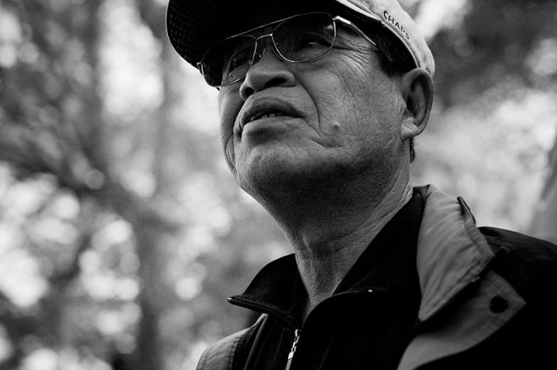 a man wearing a hat and glasses looks up