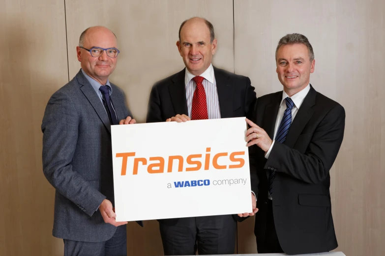 three men holding up a white board with a transicc message