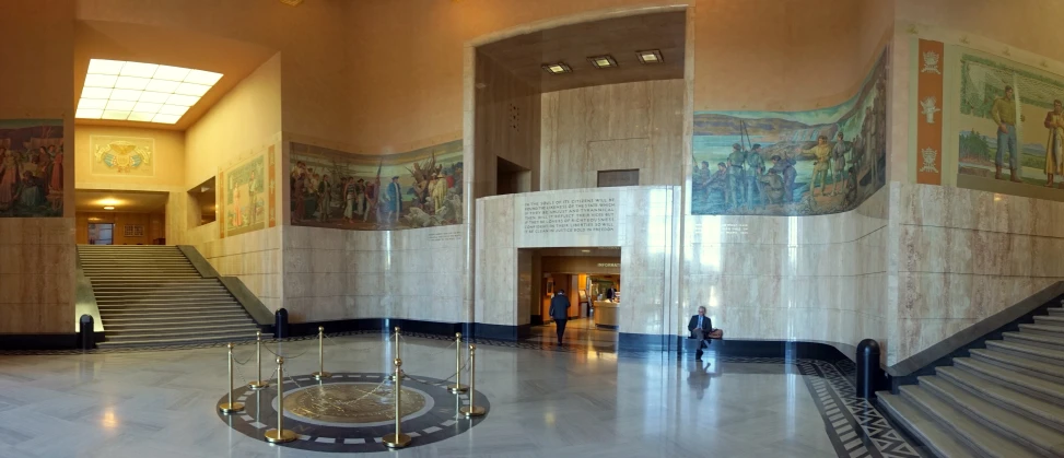 a foyer with two people walking by a set of stairs