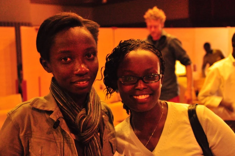 an attractive young woman standing next to a male in a gray shirt