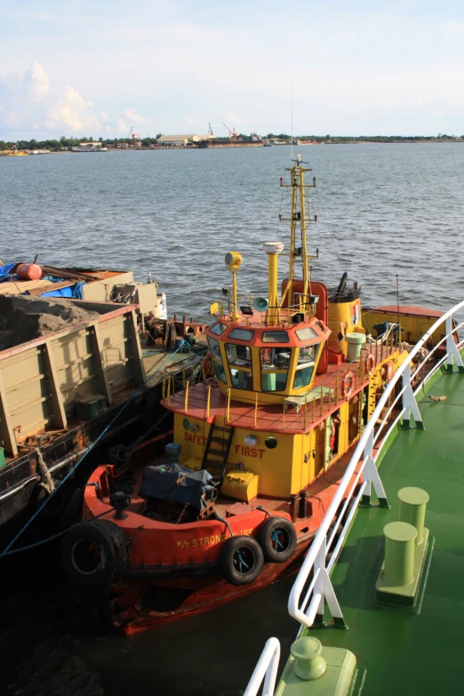 a yellow and red boat in a harbor