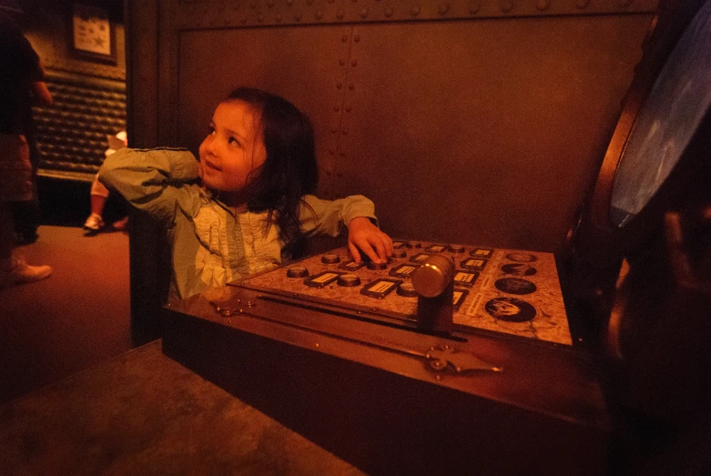 a little girl sitting next to a sound board