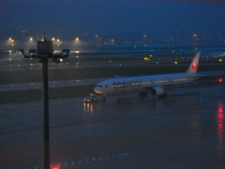 the large plane is on the wet runway