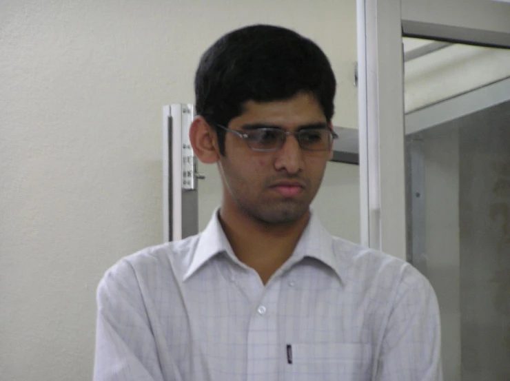 a man wearing glasses looks in an elevator