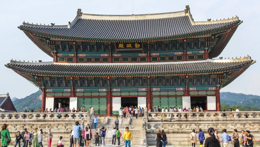 people standing outside a building with steps and a clock on the top of it