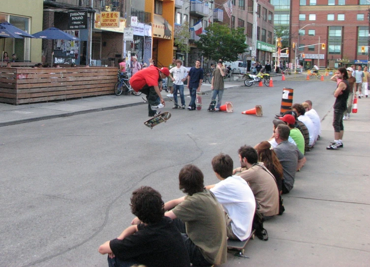 spectators watching skateboarder jump off the ledge of a halfpipe