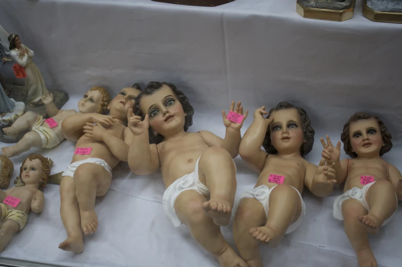 seven porcelain babies in diapers with various decorations