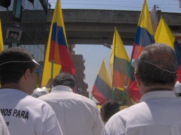 a group of men walking down a street with flags on them