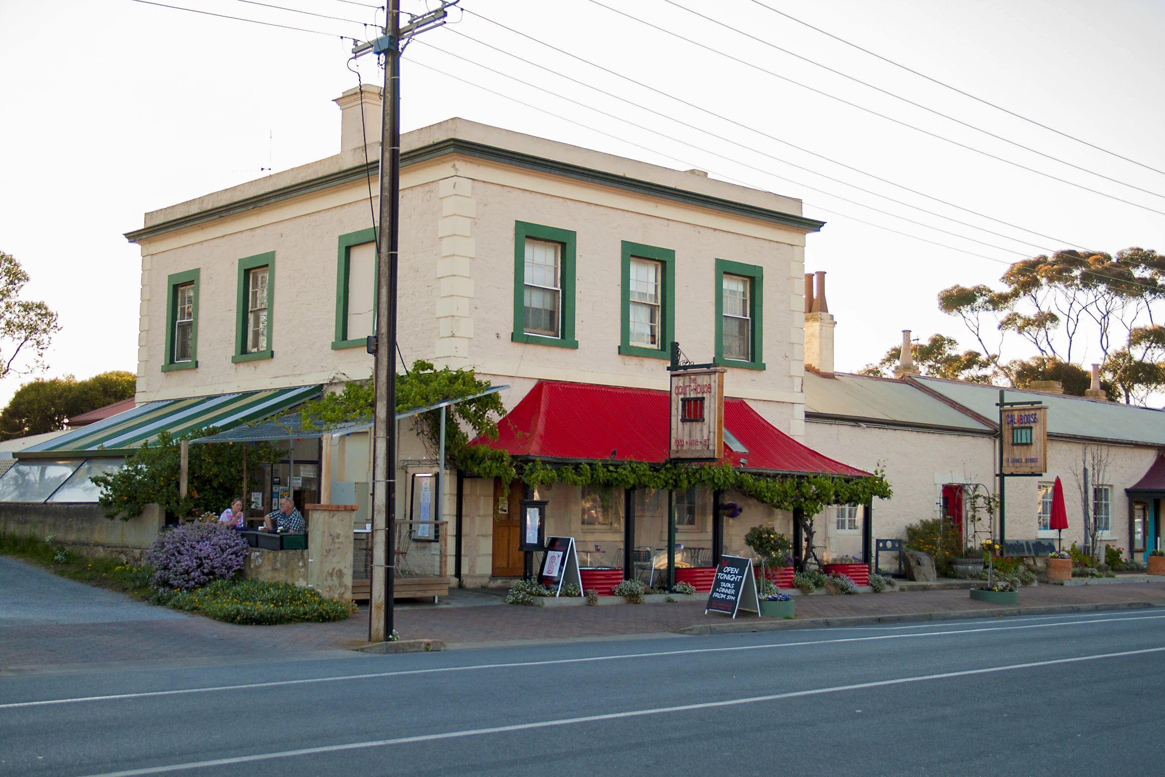 an old victorian style building has red awnings on the front