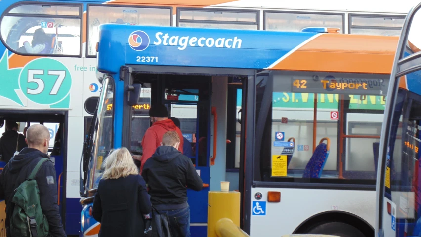 people are getting on and off of a blue, orange, and white bus