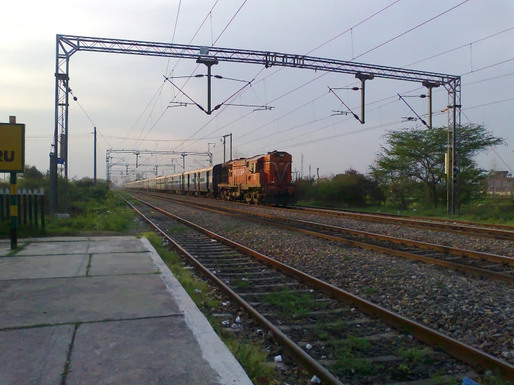 an old train on tracks with wires overhead