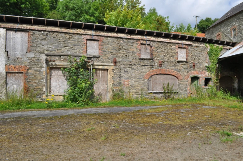 a dirty, run down building with boarded up windows