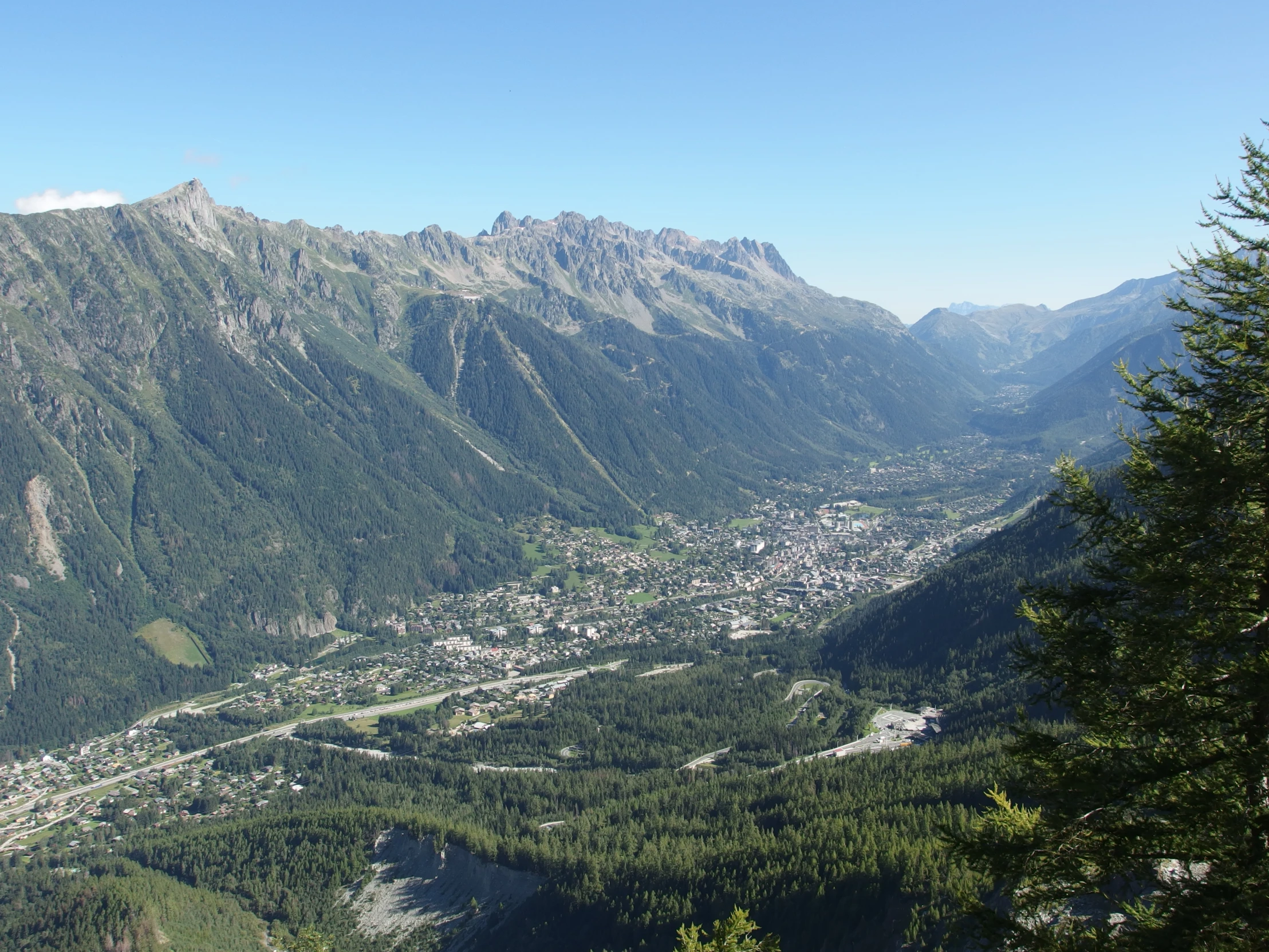 a view looking down at a city nestled in the mountains