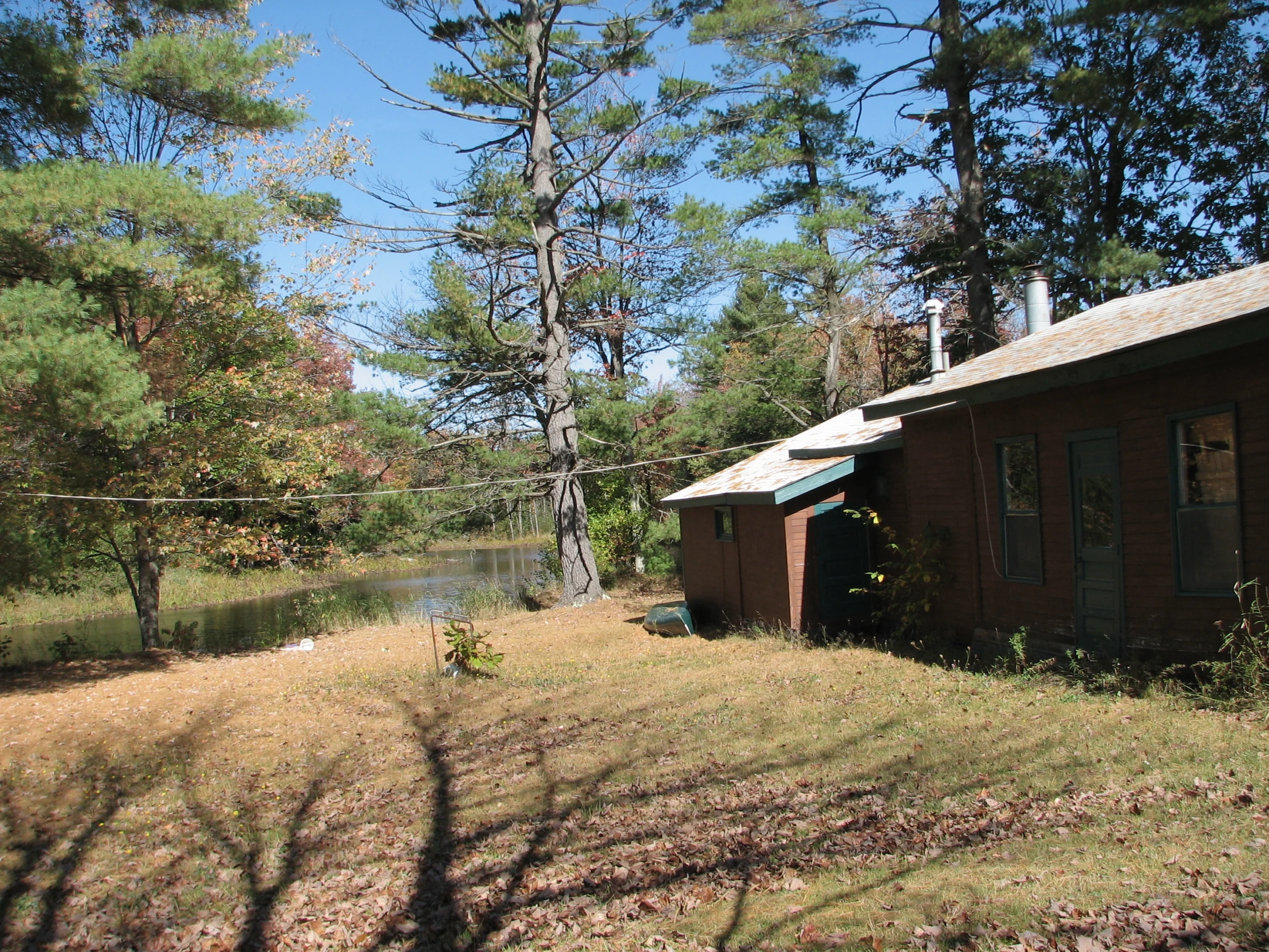 an outdoor house on the land surrounded by trees