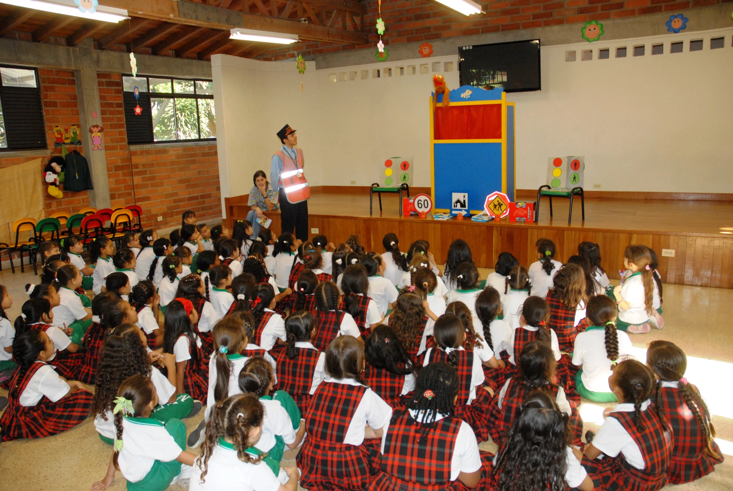 there is a group of children in school uniforms sitting and standing in front of a teacher