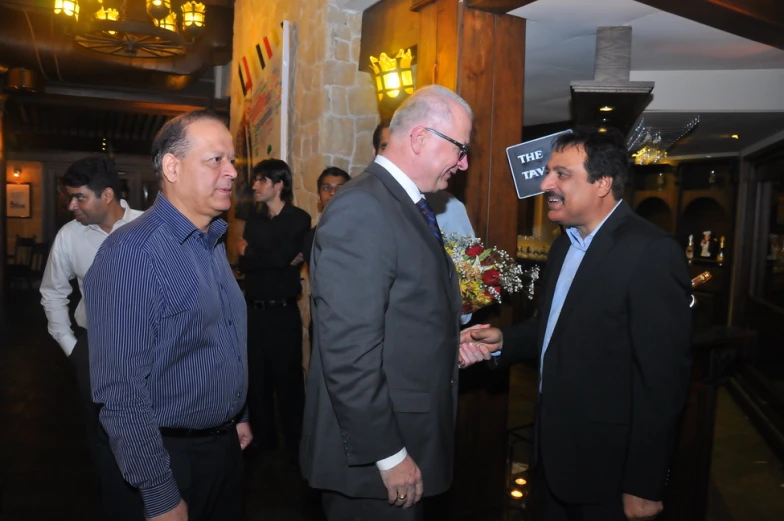 a group of men standing around each other talking