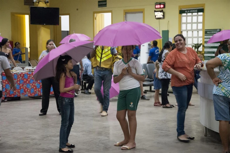 several people in a banquet hall holding umbrellas