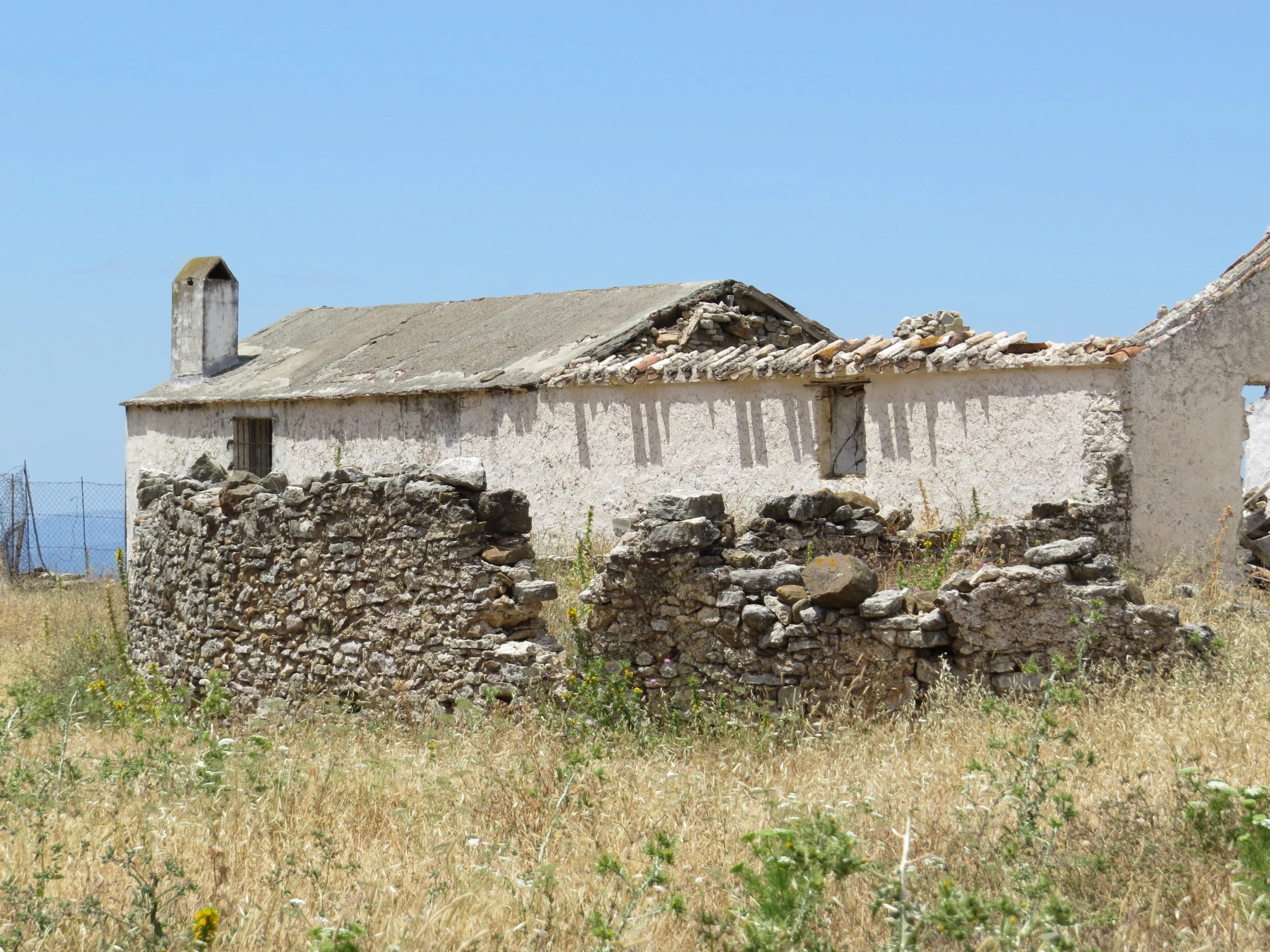 an old building with a very large pile of rocks next to it