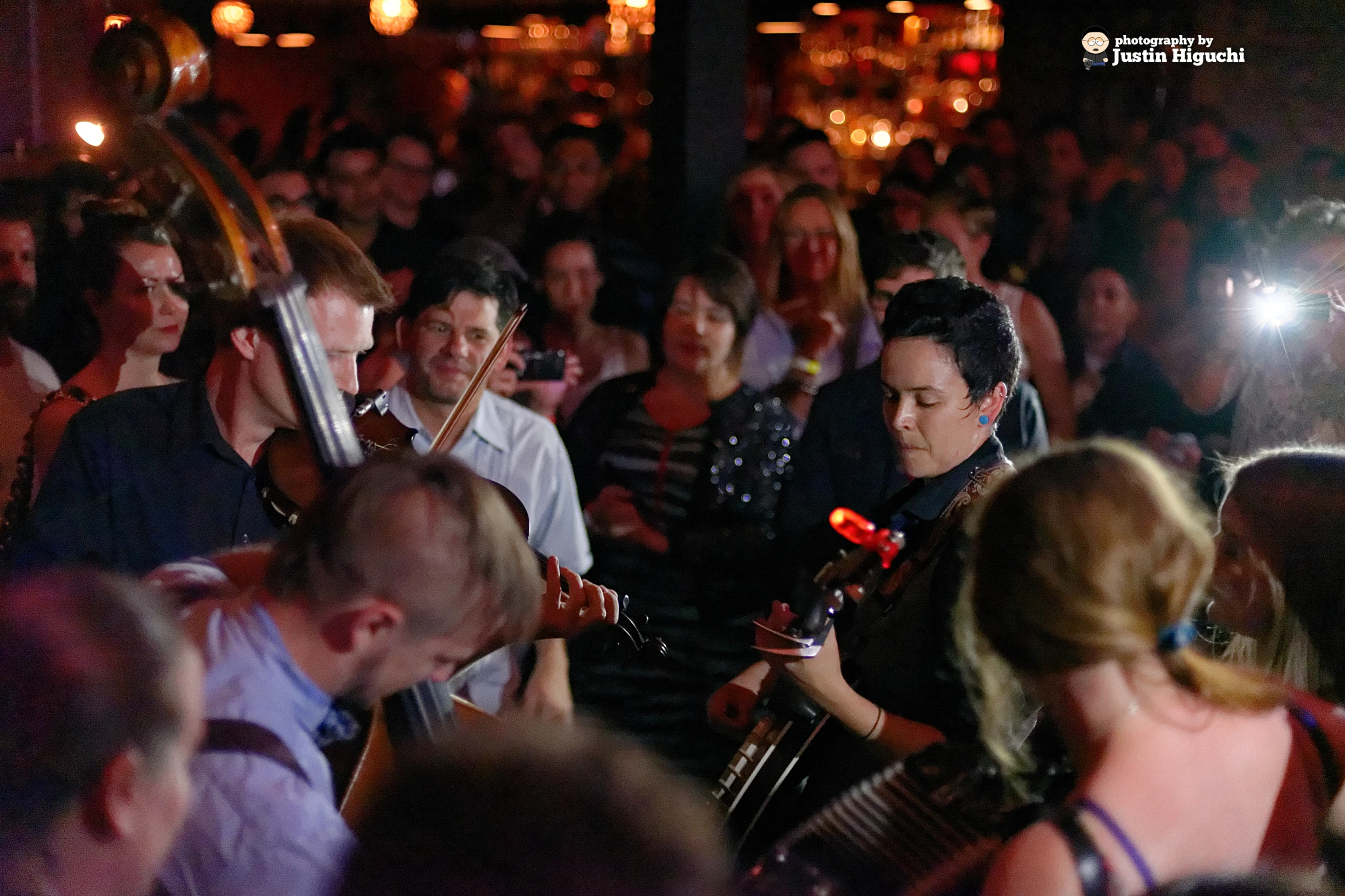 a large group of people are shown as one plays the guitar