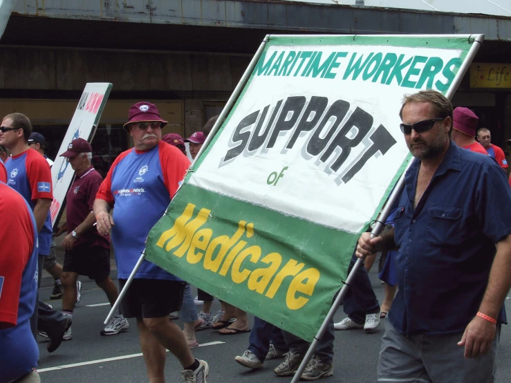 many people in a parade holding signs and walking