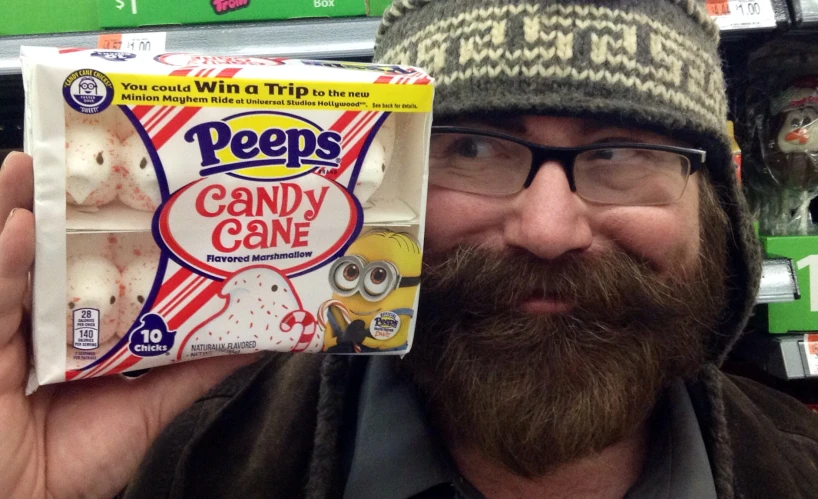 a man is holding a box of peeps candy cane